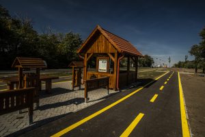 A térkő burkolatú pihenőhelyeken padok és asztalok szolgálják a megpihenni vágyó biciklisek kényelmét. (Győrújbaráti kerékpáros pihenő)